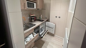 Una cocina compacta equipada con microondas, cafetera y lavavajillas.