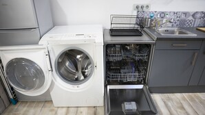 Uma cozinha compacta com máquina de lavar e secar integradas, lava-louças e pia.