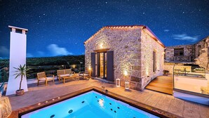 A stone building with a pool and outdoor seating, surrounded by a starry night sky. - Akalli Villa Private Pool & Hot Tub (Paraskevi)