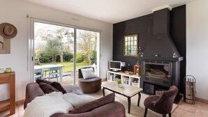 Ein modernes Wohnzimmer mit Kamin, einer Couch, einem Couchtisch und einem Fernseher.