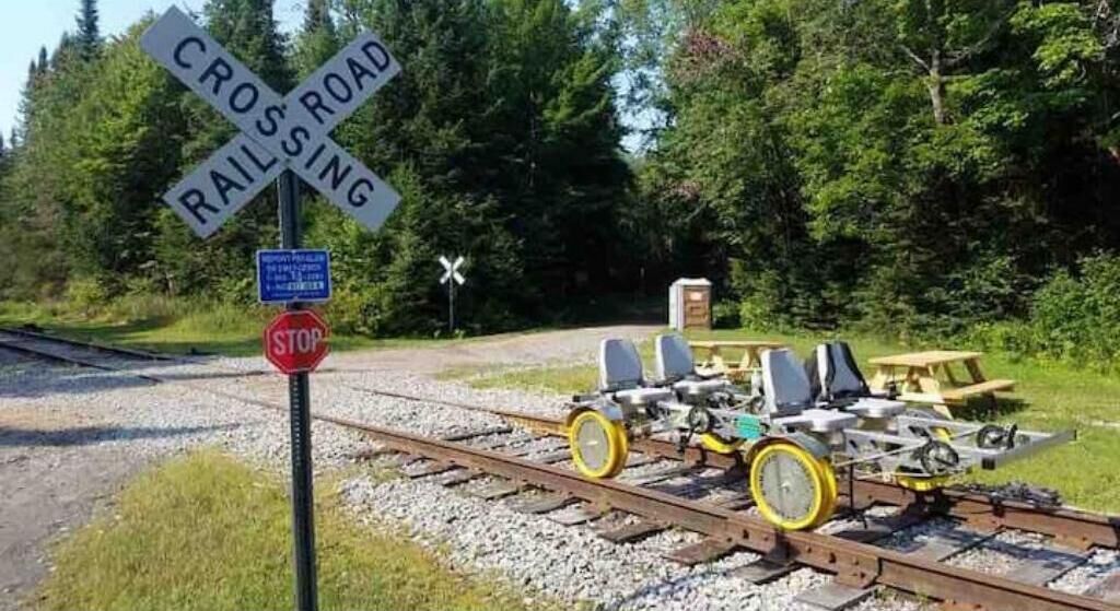 Un paso de tren con una señal de alto y una señal de advertencia.