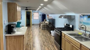 Une cuisine de taille réduite, avec des meubles de rangement en bois, une cuisinière et un évier.