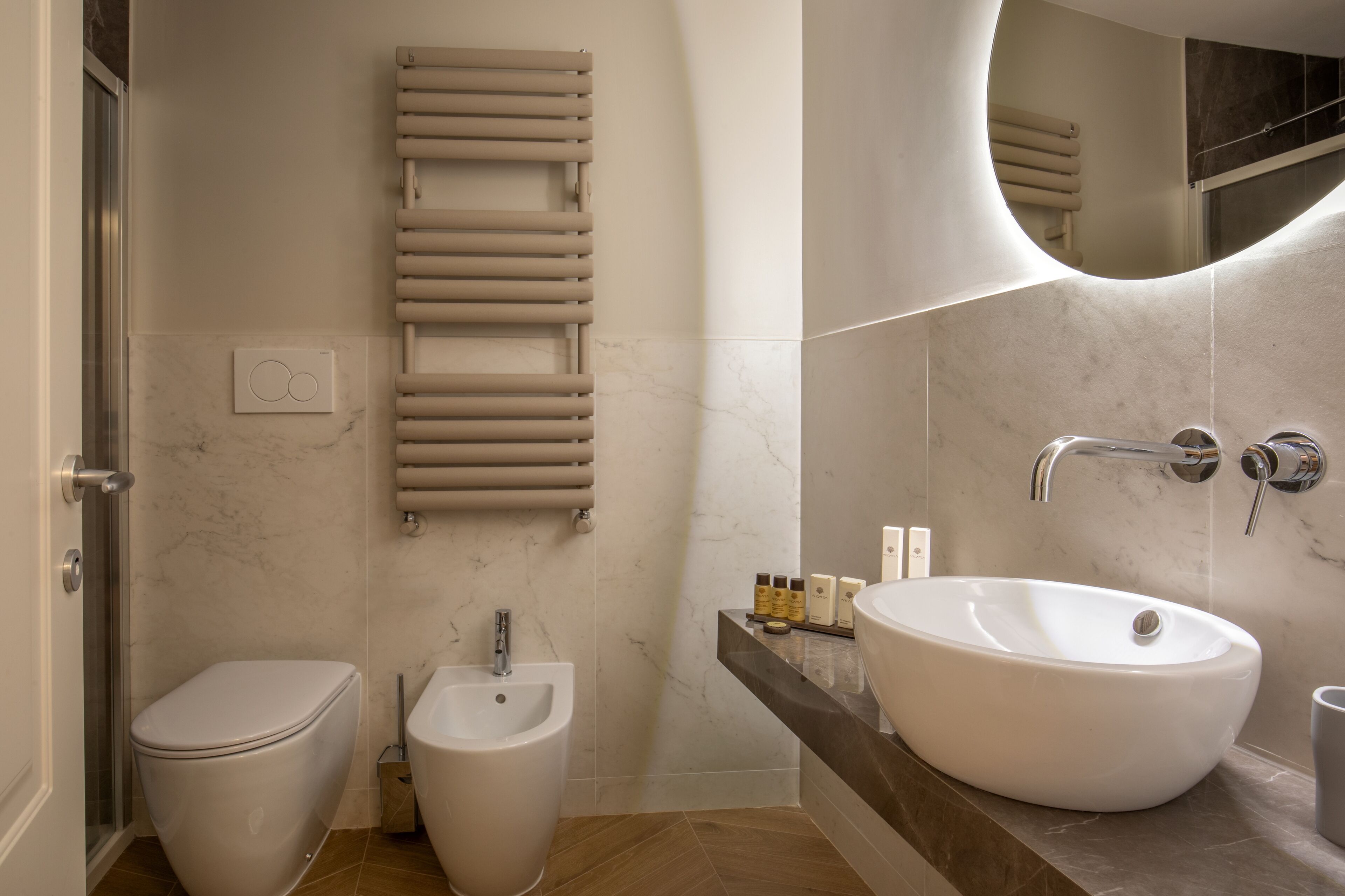 A modern bathroom with a toilet, bidet, and large sink.