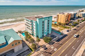 A coastal hotel with a pool, multiple floors, and a view of the beach and ocean. - Arena De Madeira 502- Premier (Madeira Beach)