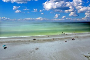 A beach with clear turquoise water and a sandy shore.