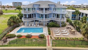A multi-story building with balconies, a swimming pool, and outdoor seating.
