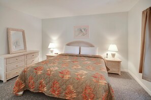 A bedroom with a bed, two bedside tables with lamps, a dresser, and a framed picture on the wall. - Amadeus 7 (Treasure Island)