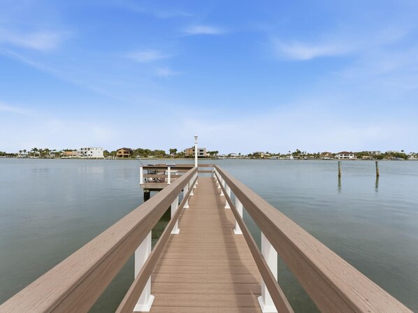 A wooden pier extending into calm water, with buildings in the background. - Amadeus 7 (Treasure Island)