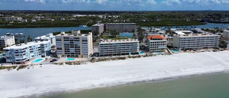 A coastal hotel with multiple buildings, a beach, and a marina.