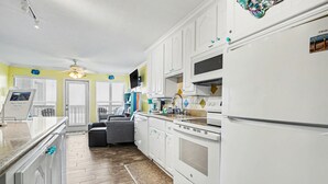A modern kitchen with white cabinets, a built-in oven, and a refrigerator. - Sandy Views - Step Right onto the Sand at Seascape Resort 2/2 condo (Galveston)