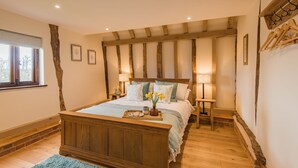 Un dormitorio con cama de madera, una mesita de noche, una lámpara y ventana con vistas.