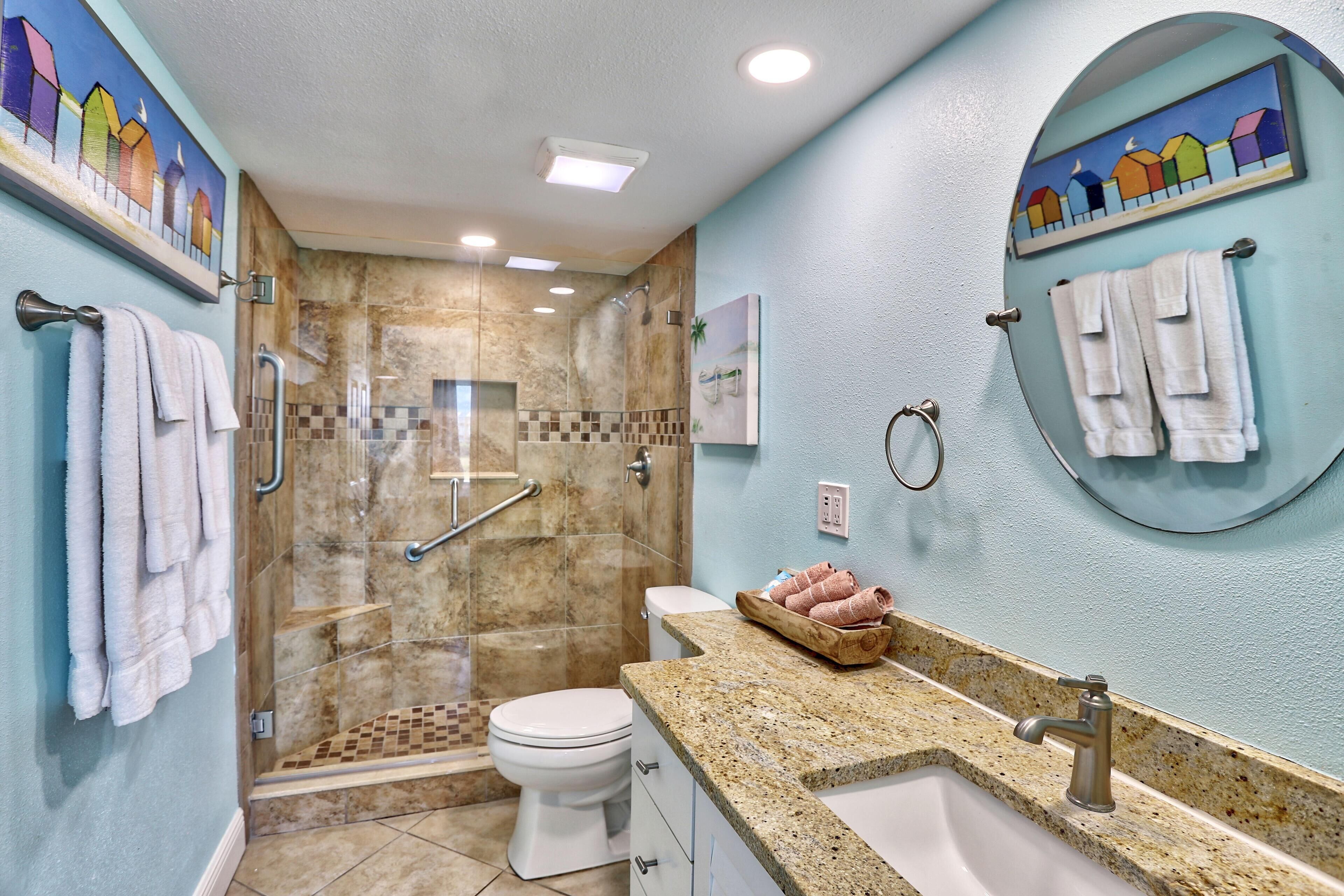 Une salle de bain avec une douche, des toilettes et un lavabo.