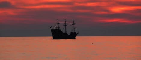 A ship at sea during sunset.