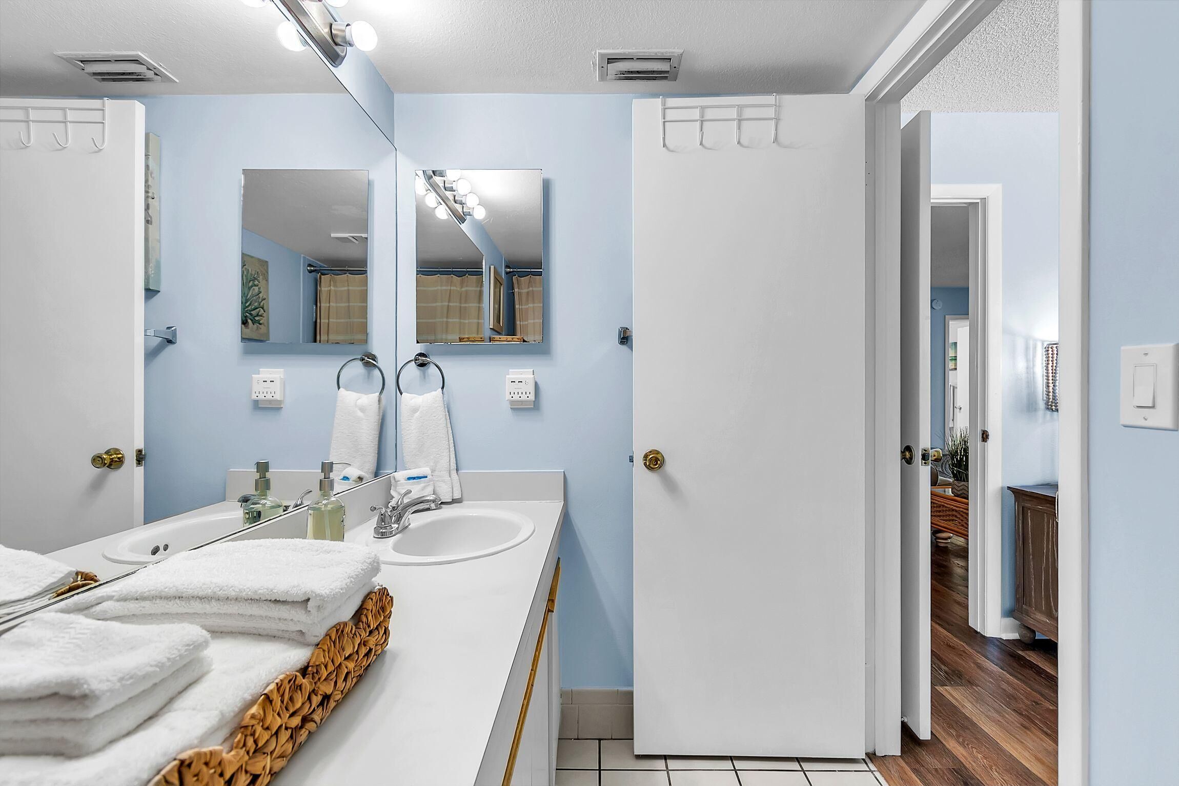 Une salle de bain avec un lavabo blanc, un miroir et un porte-serviettes.