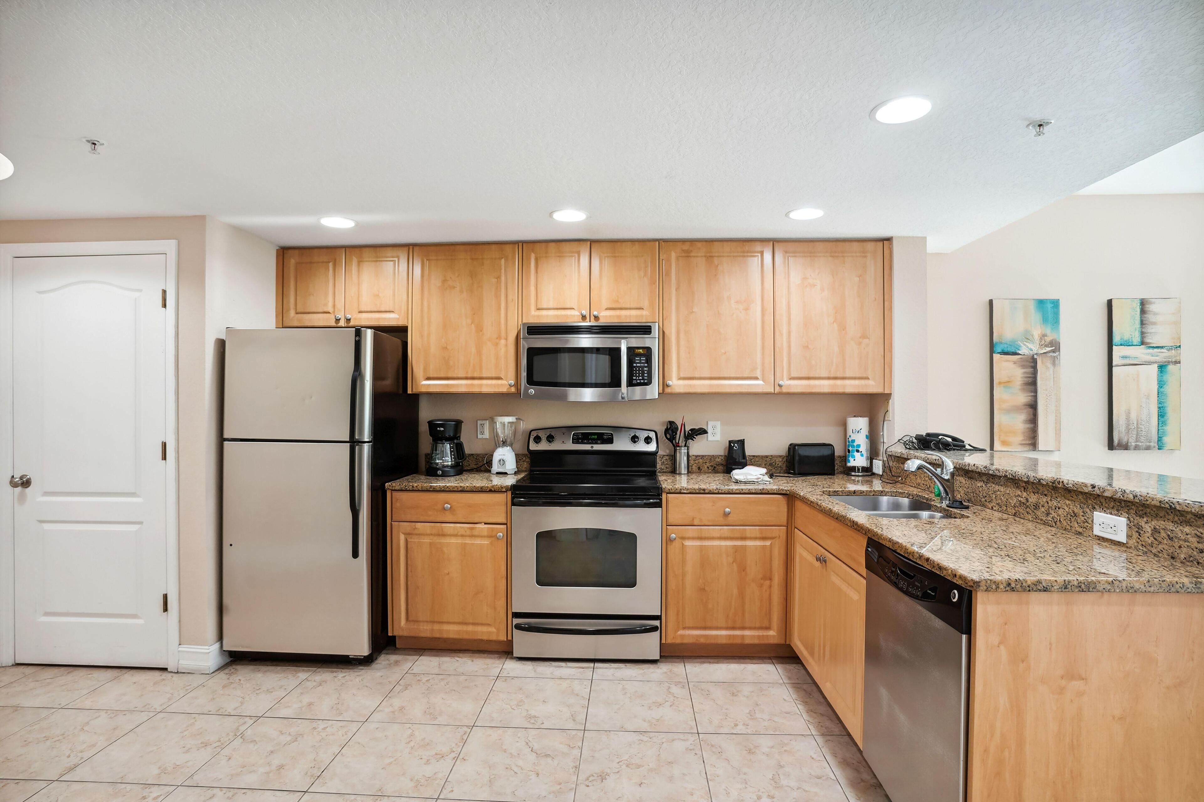 A modern kitchen with wooden cabinets, stainless steel appliances, and granite countertops.