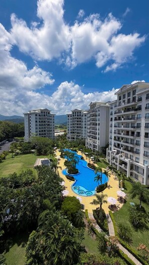 A resort with a swimming pool, multiple high-rise buildings, and lush greenery.