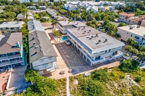 An aerial view of a coastal hotel with multiple buildings, a pool, and a beach area. - Gulfside Villas 3 (Indian Rocks Beach)