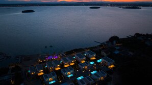 A coastal resort with modern buildings, a marina, and a sunset view. - The Palms Resort - Villa President Beach I (Tkon)