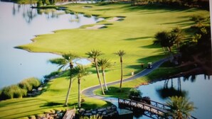 A golf course with a water body, palm trees, and a bridge. - Exquisite, one of a kind place located in Lake Las Vegas Resort. Lovely decor  (Henderson)