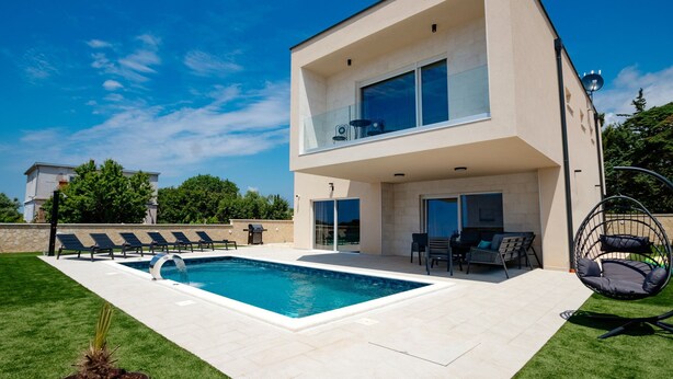 A modern two-story house with a swimming pool, outdoor seating, and a balcony. - Villa Emerilla with Pool (Pula)