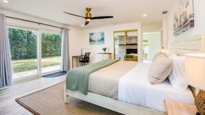 A bedroom with a bed, a desk, a chair, a ceiling fan, and a window with curtains. - Relaxing pool, Elegant and FUN vacation home! (Clearwater)