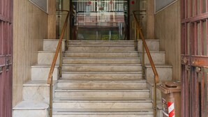Uma escadaria de mármore que leva a uma porta com um tapete de entrada com a inscrição "Condominio via F. Del Carretto N° 26".