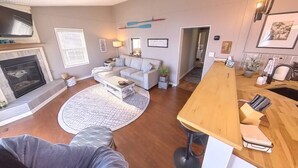 Un salon moderne avec une cheminée, un canapé, une table basse et une table à manger en bois.