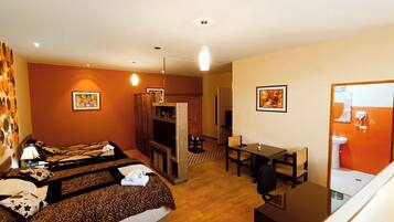 Una habitación de hotel con cama, escritorio, silla, televisor y baño.