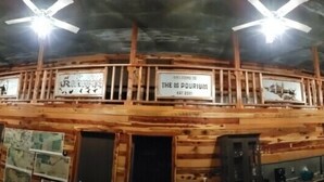 Eine Holzhütte mit Barbereich, Deckenventilatoren und montierten Tierköpfen.