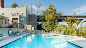 En swimmingpool med liggestole og en bygning med et skilt.
