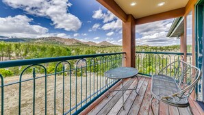 A balcony with a metal railing, a small table, and a metal chair. - Scenic Alto Getaway w/ Mountain Views & Hot Tub! (Alto)