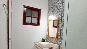 Ein kleines Badezimmer mit Toilette, Waschbecken und Spiegel.