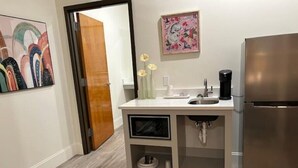 A modern kitchen with a stainless steel refrigerator, a white countertop, and a built-in sink.