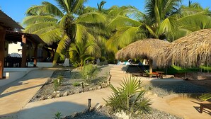 Um resort com palmeiras, piscina e construções com telhado de palha.