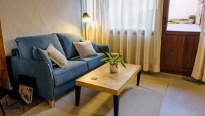 Un salon avec un canapé bleu, une table basse en bois et une lampe.