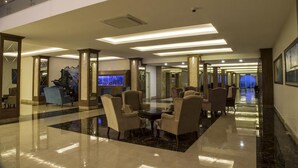 A spacious lobby with a high ceiling, modern lighting, and comfortable seating areas. - Seven Seas Palmeras Bay (Alanya)