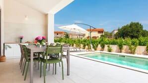 A modern outdoor dining area with a pool and a view of the neighborhood. - Echo villa, Istra, pool/jacuzzi, BBQ, pet friendly (Šegotići)