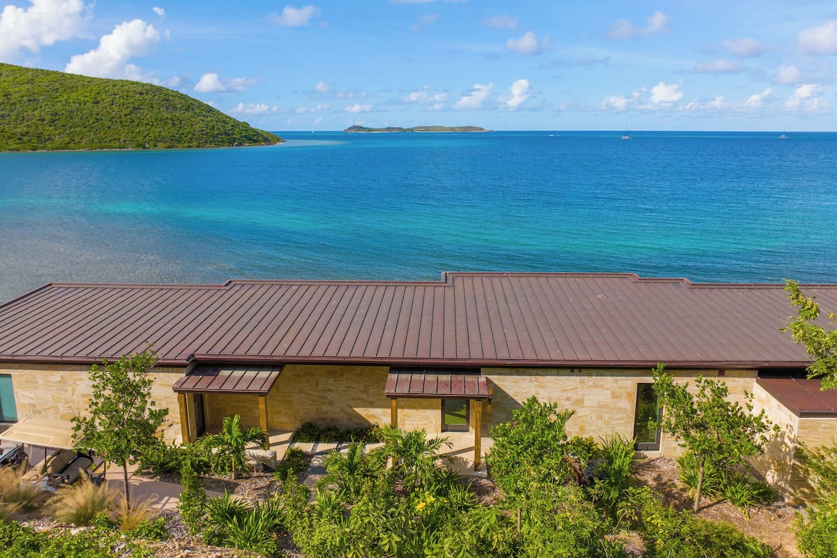 A coastal building with a wooden deck and a view of the sea.