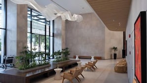 A spacious lobby with a modern design, featuring a long reception desk, comfortable seating areas, and large windows allowing natural light. - December Hotel (Nha Trang)