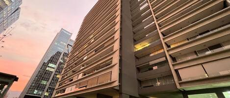 Un edificio moderno con un diseño arquitectónico distintivo, que destaca por un voladizo prominente y varios balcones.