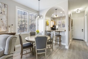 Relax in this open-plan living space with a round dining table, sofa, and kitchen area through an archway.
