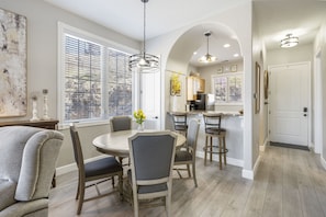 Relax in this open-plan living space with a round dining table, sofa, and kitchen area through an archway.