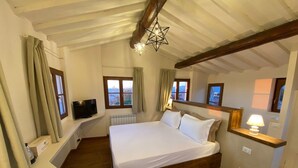 Un dormitorio con una cama de madera, un televisor en un estante y una lámpara con forma de estrella.