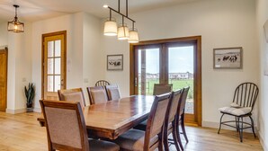 A dining area with a wooden table and chairs, a potted plant, and a view through a glass door. - Large Group Getaway in Georgetown w/ Private Pool! (Georgetown)