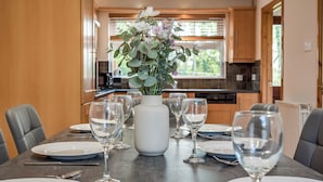 A dining table set with plates, cutlery, and wine glasses, centered with a vase of flowers. - Stylish & spacious entire 3+1BR house in Lisburn(near Belfast)with parking  (Lisburn)
