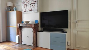 Relax in this stylish living room with a flat-screen TV, entertainment unit, and wooden cabinet.