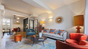 Een moderne woonkamer met een bank, fauteuils, een salontafel en een eethoek met stoelen.