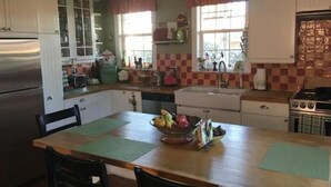 A kitchen with white cabinets, a stainless steel refrigerator, a stove, and a sink. - Charming cozy cottage downtown Petaluma (Petaluma)