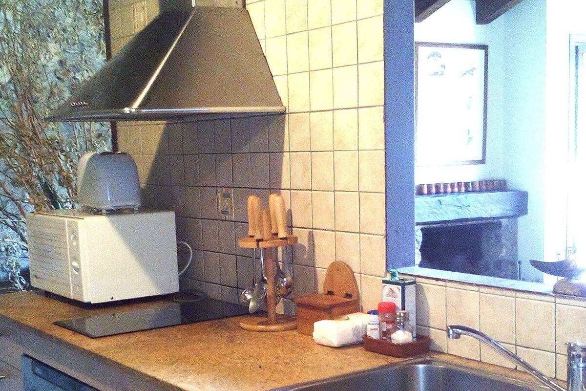A kitchen with a stainless steel sink, a toaster, and a knife block.