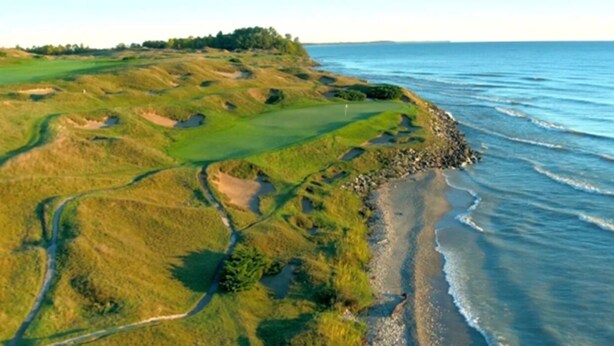Ein Küsten-Golfplatz mit Sandstrand und Blick auf den Ozean.